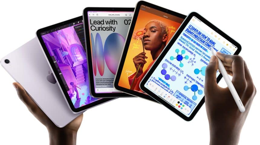 Hands holding multiple iPads displaying various apps.