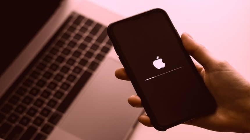 iPhone with Apple logo near MacBook.
