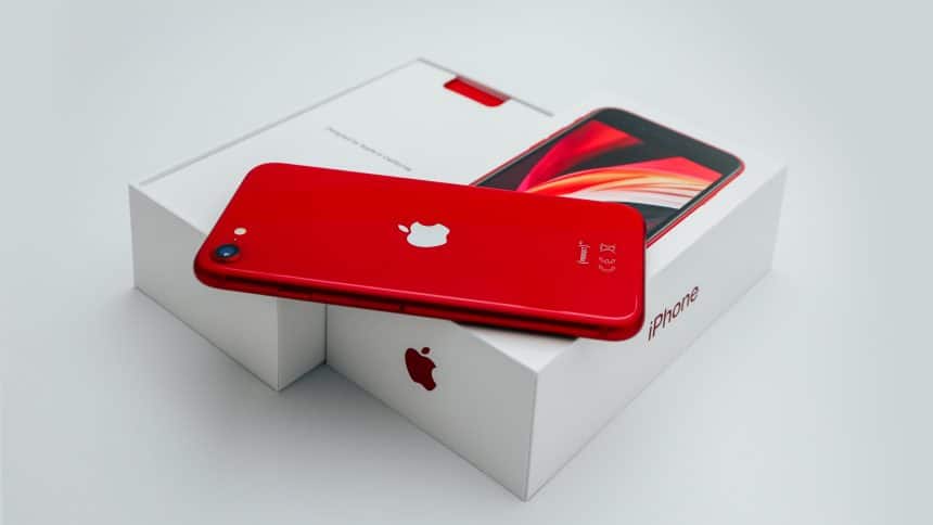 Red iPhone SE placed on its box.
