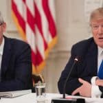 Tim Cook and Donald Trump speaking at a meeting.
