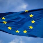 European Union flag waving against blue sky.