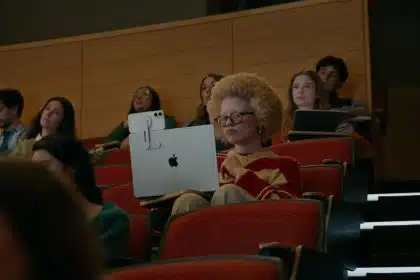 Student using iPhone and MacBook with accessibility tools in a lecture hall.