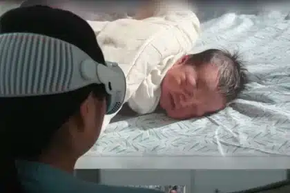 Woman wearing Apple Vision Pro watches a 3D video of a newborn baby.