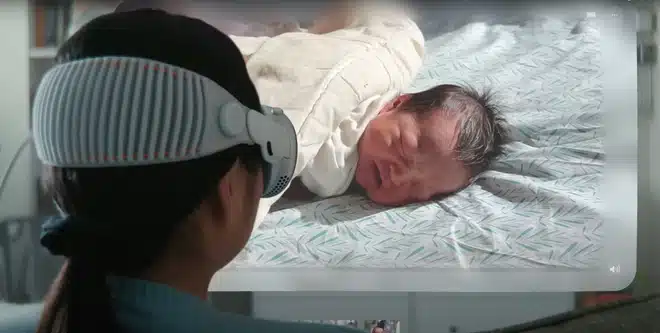 Woman wearing Apple Vision Pro watches a 3D video of a newborn baby.