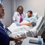 Doctor and patient using an iPad at Emory Hospital bedside.