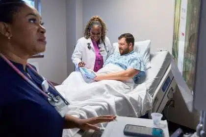 Doctor and patient using an iPad at Emory Hospital bedside.