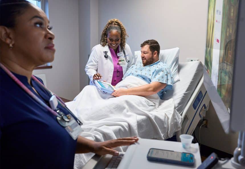 Doctor and patient using an iPad at Emory Hospital bedside.