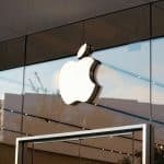 White Apple logo displayed on the glass exterior of an Apple Store.