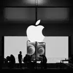 Apple Store interior with large Apple logo and people working inside.