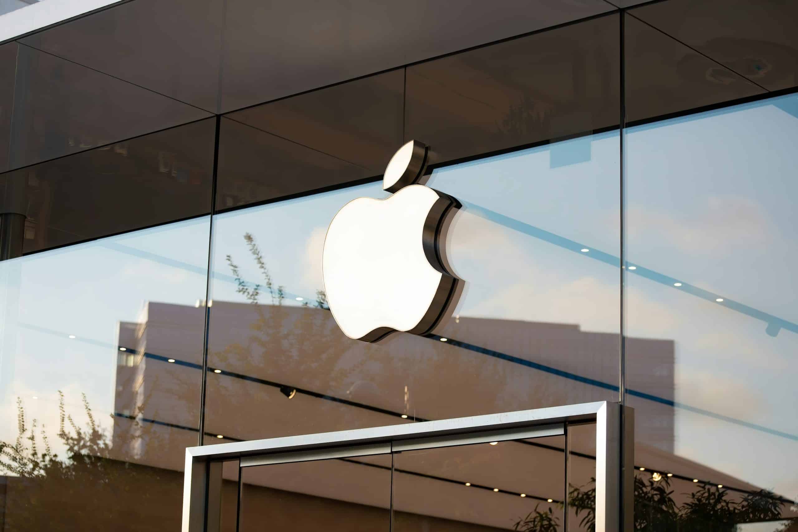 White Apple logo displayed on the glass exterior of an Apple Store.