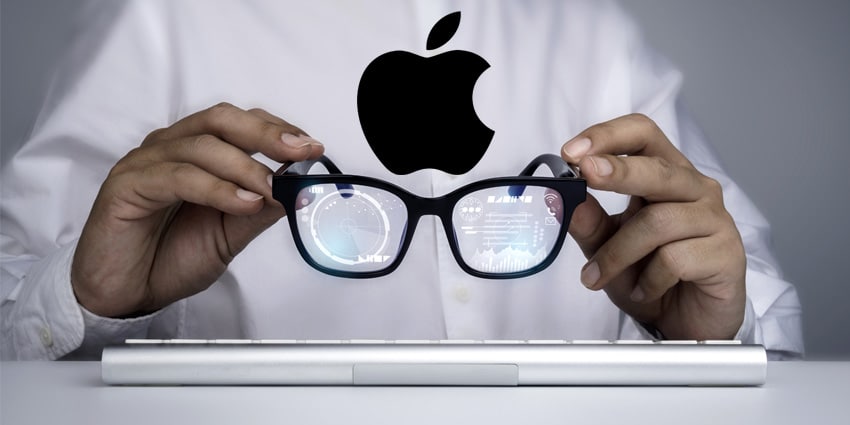 Person holding Apple smart glasses with digital data reflected in the lenses.