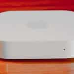 Apple AirPort Express router on a wooden surface.