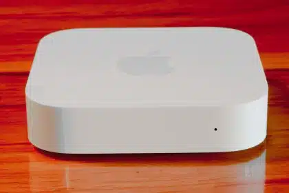Apple AirPort Express router on a wooden surface.