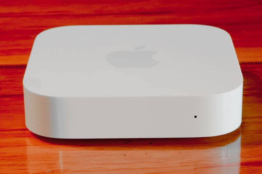 Apple AirPort Express router on a wooden surface.