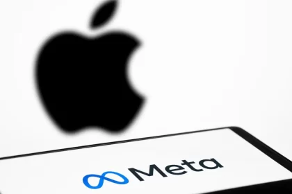 Meta logo on a screen with a blurred Apple logo in the background.