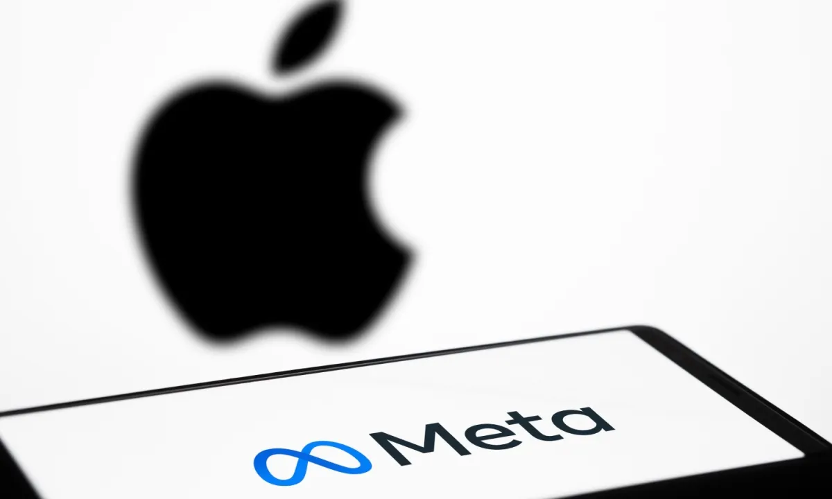 Meta logo on a screen with a blurred Apple logo in the background.