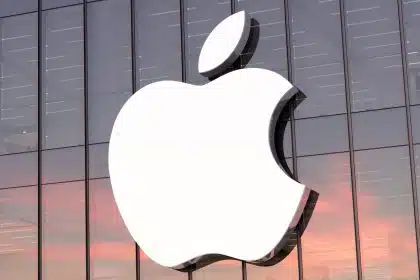 Apple logo on the glass exterior of a corporate building during sunset.