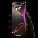 Hand holding a locked iPhone with a dark screen background.