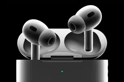AirPods Pro 3 earbuds hovering above their open charging case against a black background.