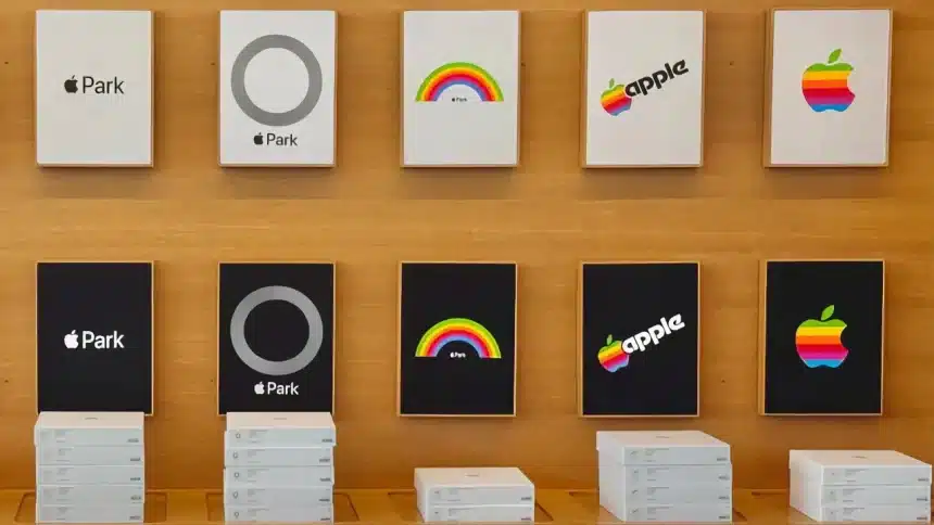 Stacks of Apple Park merchandise boxes beneath framed retro rainbow and monochrome Apple logos.