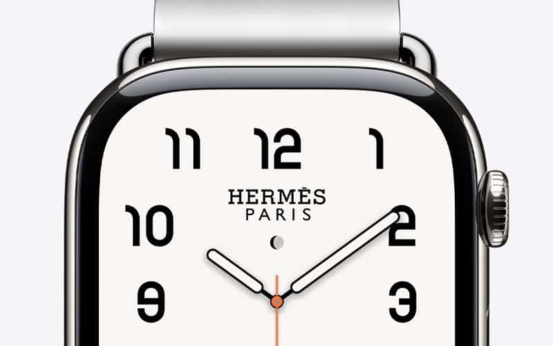 Close-up of an Apple Watch Hermès with a white analog watch face.