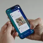 Hands holding an iPhone showing a screenshot preview with ‘Highlight to Search’ and AI action buttons.