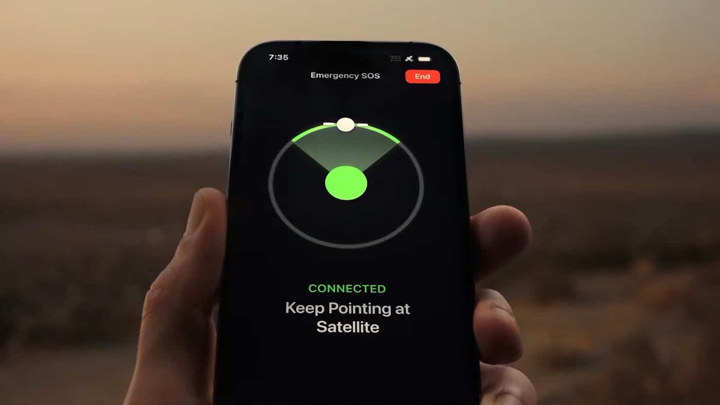 Hand holding an iPhone displaying the Emergency SOS satellite connection screen.