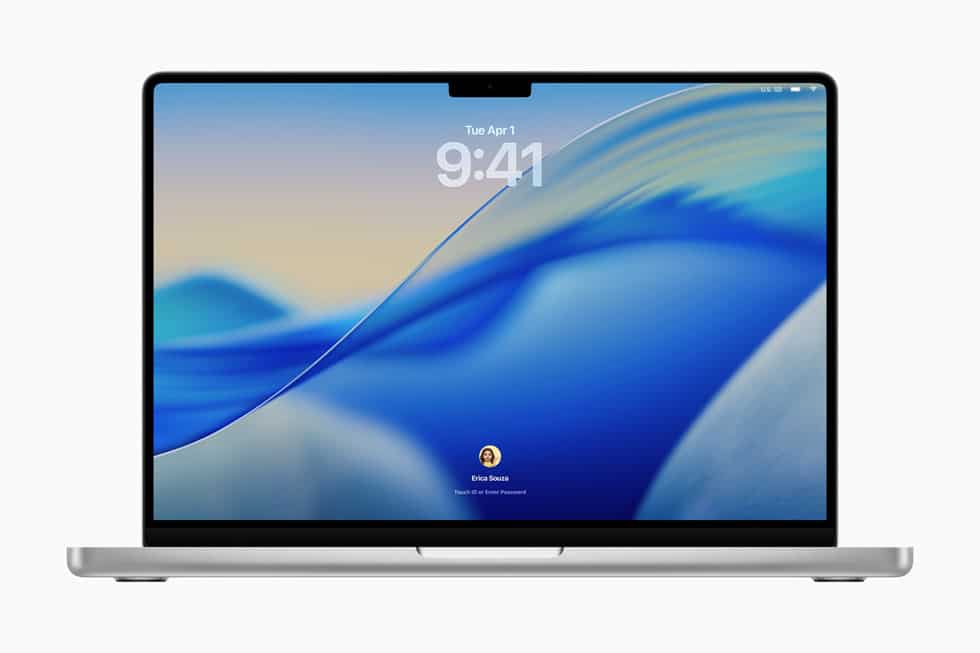 MacBook Pro lock screen with blue wave wallpaper, digital clock at top, and user avatar at bottom.