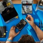 Technician repairing an iPhone on a workbench.