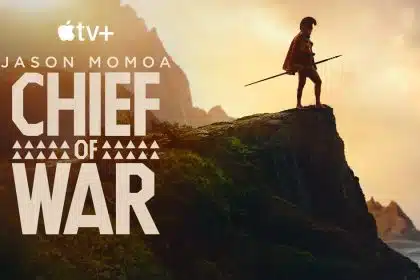 Jason Momoa stands on a cliff holding a spear in the promotional poster for Chief of War on Apple TV+.