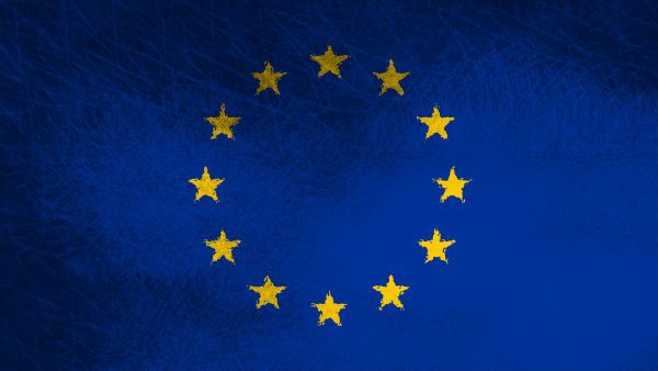 European Union flag with a circle of yellow stars on a blue background.