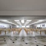 Empty Apple Store with wooden tables and glass entrance.