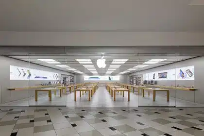 Empty Apple Store with wooden tables and glass entrance.