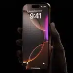 Hand holding an iPhone with lock screen displayed.