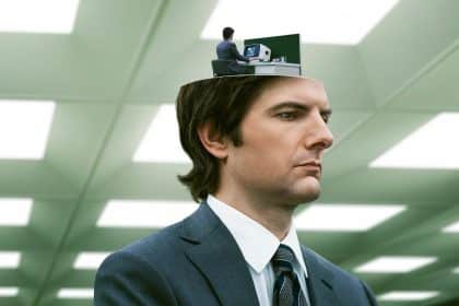 Man in a suit with an open head showing a smaller version of himself working at a desk inside.
