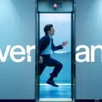 Man in a suit running through elevator with Severance title in background.