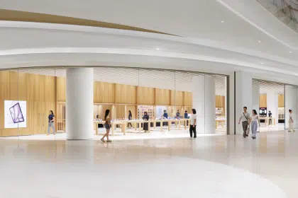 Apple Store in Shenzhen with glass walls, wood interior, and customers walking inside the mall.