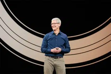 Tim Cook smiles while speaking on stage at an Apple event.