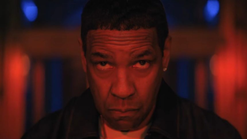 Denzel Washington stares intensely under red lighting.