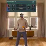 Man playing a virtual game using Apple Vision Pro headset and controllers.