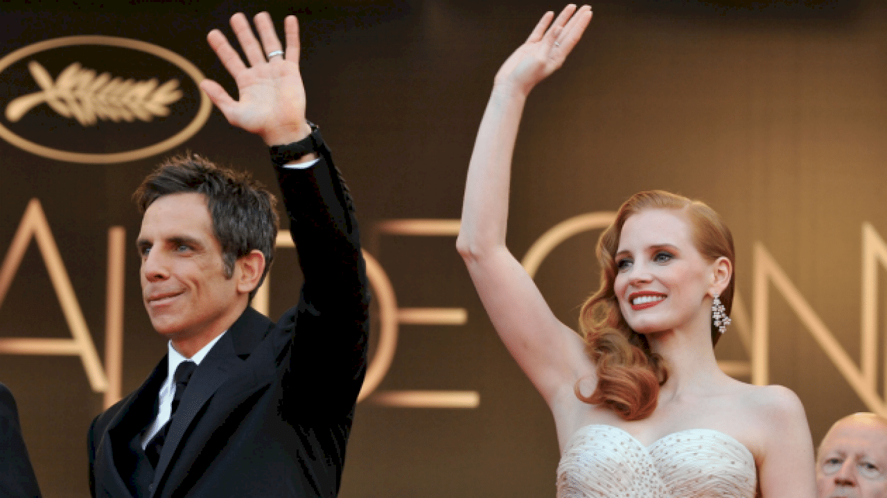 Ben Stiller and Jessica Chastain wave at a red carpet event.