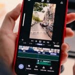 Person editing a video on an iPhone using Adobe Premiere.