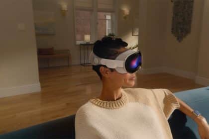 Person wearing Apple Vision Pro headset while sitting on a couch indoors.