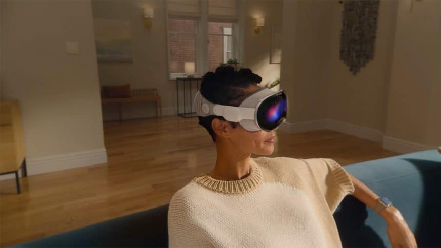 Person wearing Apple Vision Pro headset while sitting on a couch indoors.