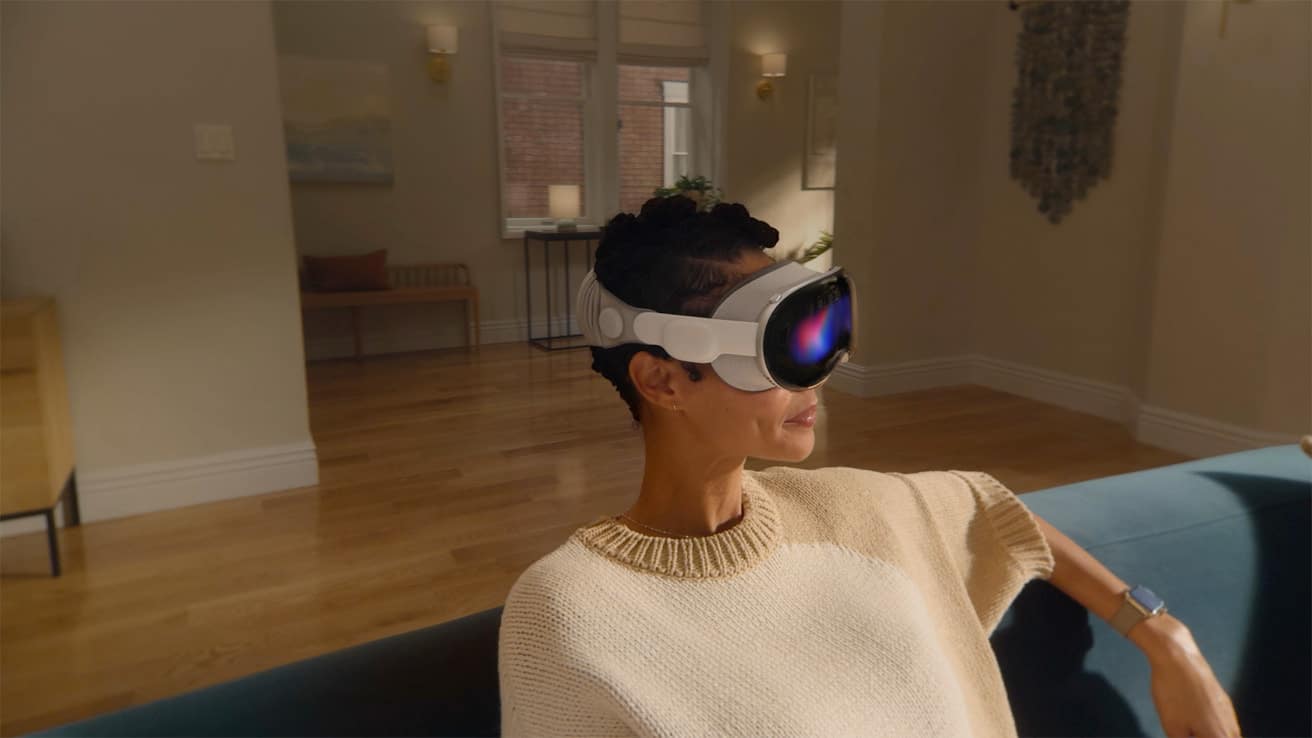 Person wearing Apple Vision Pro headset while sitting on a couch indoors.