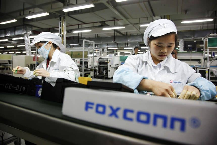 Foxconn factory workers assembling electronics on a production line.