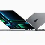 Two MacBook Pro laptops half-open, facing opposite directions.