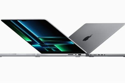 Two MacBook Pro laptops half-open, facing opposite directions.