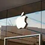 The Apple logo displayed on the glass exterior of an Apple Store.