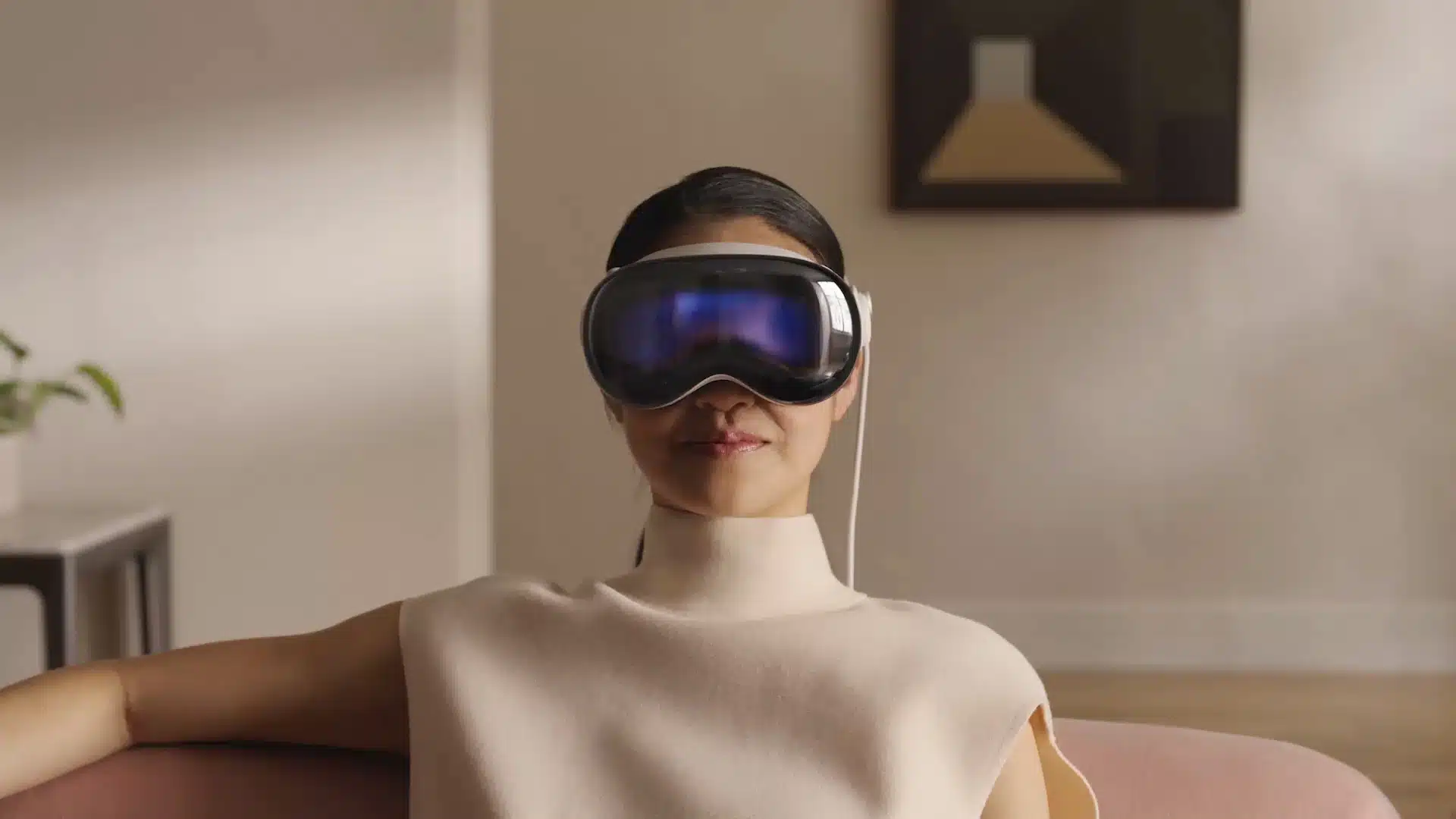 Person wearing an Apple Vision Pro headset while sitting indoors.
